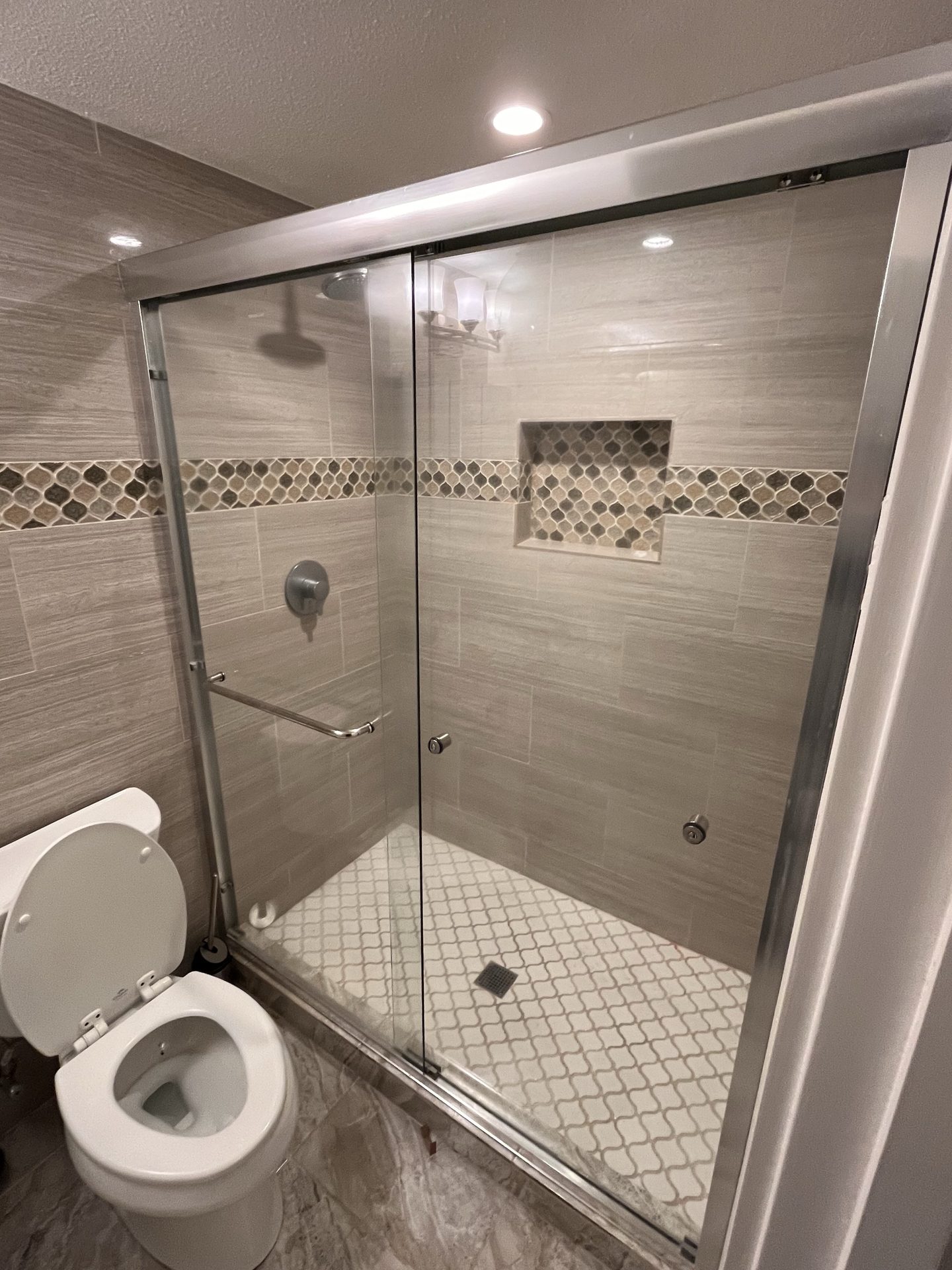 Tiled shower with a glass sliding door